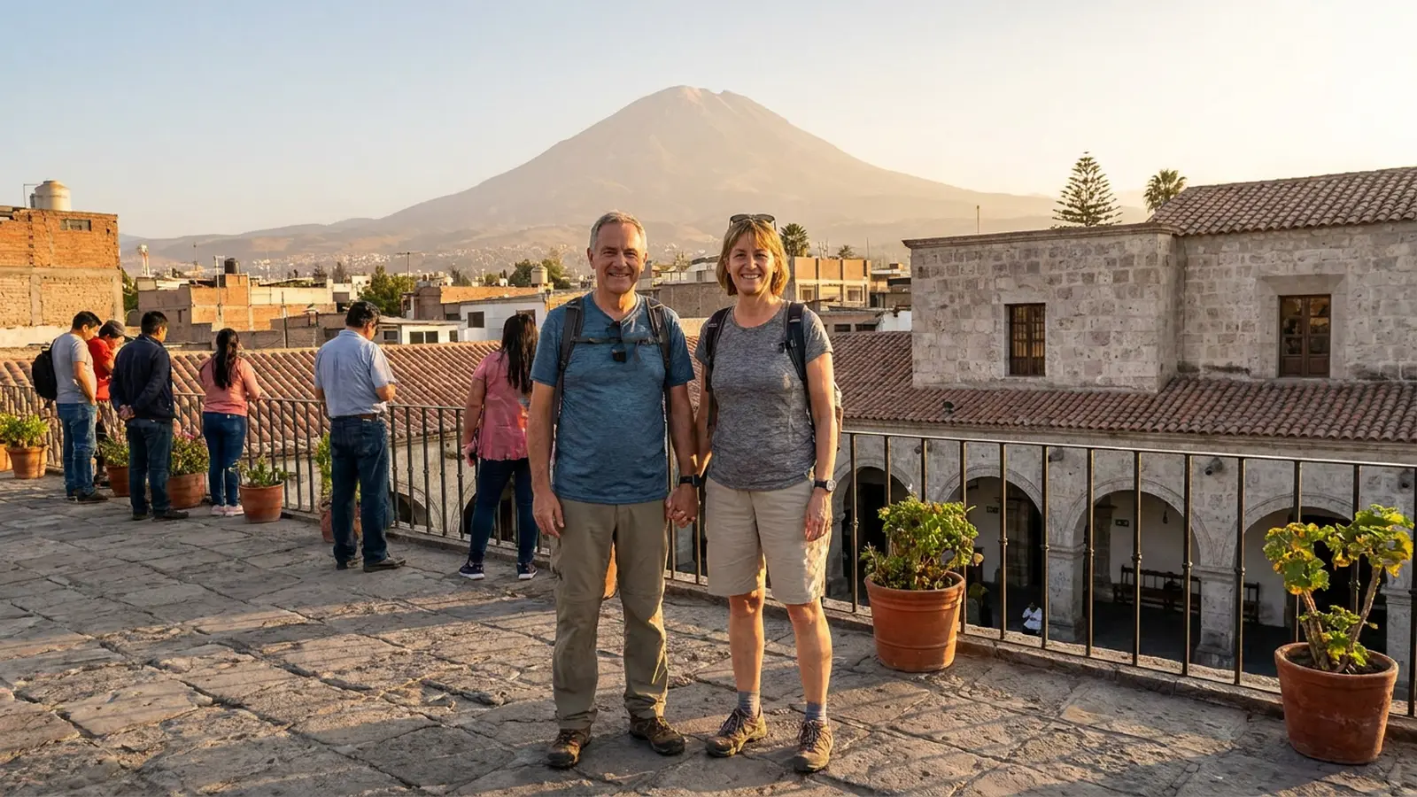 Paar auf einem Aussichtspunkt ueber Arequipa mit dem Vulkan Misti im Hintergrund im warmen Abendlicht.